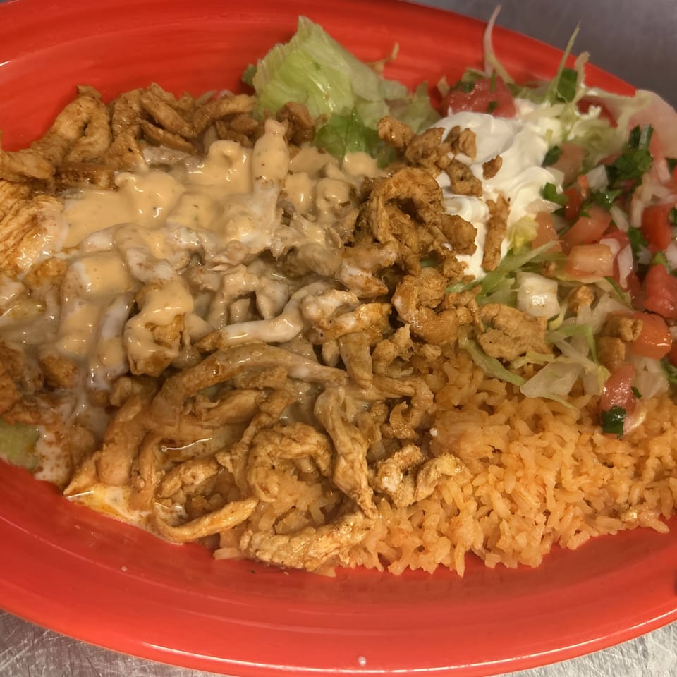 La Fiesta Mexican's chicken dish with rice, lettuce, pico de gallo, sour cream, and cheese sauce.